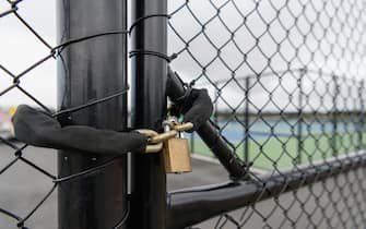 CHRISTCHURCH, NEW ZEALAND - MARCH 21: A lock is seen in front of the tennis courts at Nga Puna Wai on March 21, 2020 in Christchurch, New Zealand. Sporting codes across New Zealand have cancelled competition in response to the ongoing COVID-19 outbreak. The New Zealand government has imposed strict border restrictions, banning all foreign visitors into the country, while New Zealand citizens and residents are required to self-isolate for 14 days. Indoor gatherings of more than 100 people have been banned with the exception of workplaces, schools, supermarkets and public transport. (Photo by Kai Schwoerer/Getty Images)