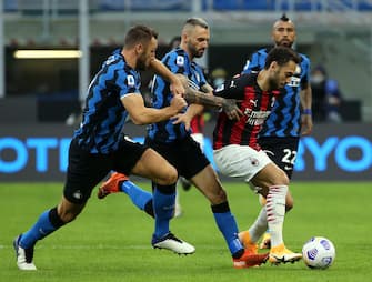AC Milan's Hakan Calhanoglu (R) challenges for the ball  with Inter Milan's  players, Stefan de Vrij (L) and Marcelo Brozovic (C), during the Italian serie A soccer match  Fc Inter and Ac Milan at Giuseppe Meazza stadium in Milan 17 October 2020.
ANSA / MATTEO BAZZI