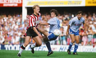 459295940 SOUTHAMPTON, UNITED KINGDOM - SEPTEMBER 14: Southampton centre forward Iain Dowie (l) beats Mark Hughes to the ball as Bryan Robson (r) looks on during a League Division One match between Southampton and Manchester United at The Dell on September 14, 1991 in Southampton, England. (Photo by Steve Morton/Allsport/Getty Images)