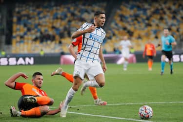 epa08778607 Achraf Hakimi (C) of Inter and Davit Khocholava (down) of Shakhtar in action during the UEFA Champions League group B soccer match between FC Shakhtar Donetsk and FC Internazionale Milan in Kiev, Ukraine, 27 October 2020.  EPA/SERGEY DOLZHENKO