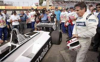 epa03363036 (FILE) A file picture dated 27 November 2011 shows former Brazilian Formula One world champion driver Nelson Piquet (R) removing his helmet after driving the car in which he won his first of three world championship titles in 1981, before the Brazilian Formula One Grand Prix at the Interlagos racetrack in Sao Paulo, Brazil. Nelson Piquet Souto Maior, known as Nelson Piquet, who was born on 17 August 1952 in Rio de Janeiro, Brazil, will celebrate his 60th birthday on 17 August 2012. Piquet won three Formula One world championship titles in 1981, 1983 and 1987, taking 23 race victories. He is currently managing his son Nelson Piquet Jr.  EPA/ANTONIO LACERDA