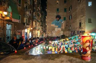 People gather at the top of the Quartieri Spagnoli in Naples on November 25, 2020 by a 1990 mural representing Argentinian football legend Diego Maradona, after the annoucement's of Maradona's death. - Argentine football legend Diego Maradona has died at the age of 60, his spokesman announced November 25, 2020. (Photo by Carlo Hermann / AFP) (Photo by CARLO HERMANN/AFP via Getty Images)