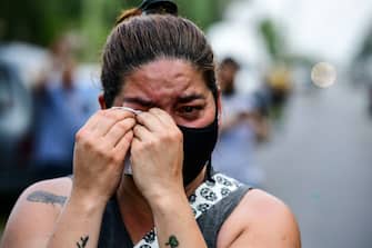 A woman mourns outside the gated community where Argentine football star Diego Maradona's home is located, in Benavidez, Buenos Aires province, where he died on November 25, 2020. (Photo by RONALDO SCHEMIDT / AFP) (Photo by RONALDO SCHEMIDT/AFP via Getty Images)