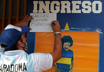 A fan of Argentinian football legend Diego Maradona writes a message reading Thank you always Maradona outside La Bombonera stadium at La Boca neighborhood, in Buenos Aires on November 25, 2020, on the day of his death. (Photo by ALEJANDRO PAGNI / AFP) (Photo by ALEJANDRO PAGNI/AFP via Getty Images)