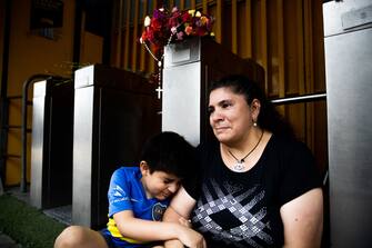 BUENOS AIRES, ARGENTINA - NOVEMBER 25: A mother and her son look dejected after the news of the death of Diego Maradona was known on November 25, 2020 in Buenos Aires, Argentina. Argentine soccer legend Diego Armando Maradona died today aged 60. (Photo by Tomas Cuesta/Getty Images)