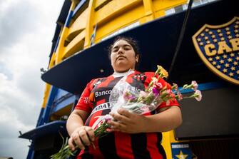 BUENOS AIRES, ARGENTINA - NOVEMBER 25: A fan with the jersey of Club AtlÃ©tico Patronato holds bouquet of flowers after the news of the death of Diego Maradona was known at Boca Junior's Bombonera Stadium on November 25, 2020 in Buenos Aires, Argentina. Argentine soccer legend Diego Armando Maradona died today aged 60. (Photo by Tomas Cuesta/Getty Images)
