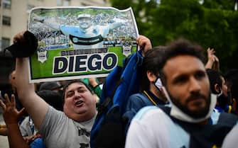 Diego Maradona's fans wait to enter the Government House to pay tribute to late football legend Diego Armando Maradona in Buenos Aires, on November 26, 2020. - Diego Maradona's coffin arrived at the presidential palace in Buenos Aires for a period of lying in state, TV reports showed, following the death of the Argentine football legend aged 60 on November 25. Hundreds of people were already lining up to pay their respects to Maradona, who died while recovering from a brain operation, the images from sports channels TyC and ESPN showed. (Photo by RONALDO SCHEMIDT / AFP) (Photo by RONALDO SCHEMIDT/AFP via Getty Images)