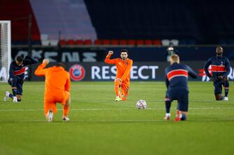 epa08872983 Players of Paris Saint-Germain (PSG) and Istanbul Basaksehir take a knee before the start of the UEFA Champions League group H soccer match between Paris Saint-Germain (PSG) and Istanbul Basaksehir at the Parc des Princes Stadium in Paris, France, 09 December 2020. The match is due to be resumed after being suspended on 08 December following alleged racist comments made by the fourth official.  EPA/IAN LANGSDON