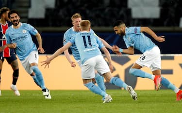 epa09166073 Manchester City's Riyad Mahrez (R) celebrates with teammates after scoring his side's second goal during the UEFA Champions League semi final, first leg soccer match between PSG and Manchester City at the Parc des Princes stadium in Paris, France, 28 April 2021.  EPA/YOAN VALAT