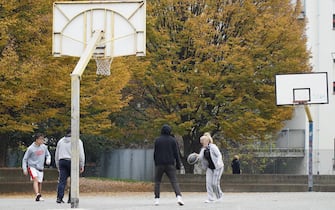 Una famiglia gioca a basket nell'area attrezzata a Torino,15 novembre 2020. Nonostante la zona rossa imposta in Piemonte dal Dpcm, e la giornata nuvolosa in tanti hanno deciso di trascorrere una domenica mattina nei parchi della cittÃ , tra cui piazza D'Armi. ANSA/JESSICA PASQUALON