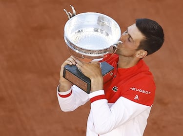 epa09268182 Novak Djokovic of Serbia celebrates with his trophy after winning against Stefanos Tsitsipas of Greece during their final match at the French Open tennis tournament at Roland Garros in Paris, France, 13 June 2021.  EPA/IAN LANGSDON