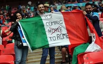 Tifose e tifosi italiani allo stadio di Wembley con una bandiera tricolore e uno slogan durante Euro 2020