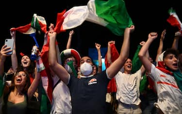 Supporters of the Italian national football team celebrate after Italy beat England 3-2 on penalty shootout to win the UEFA EURO 2020 final football match, at the Fori Imperiali fanzone, in Rome on July 11, 2021. (Photo by Vincenzo PINTO / AFP) (Photo by VINCENZO PINTO/AFP via Getty Images)