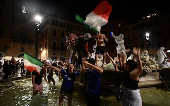 Supporter of the Italian national football team celebrate after Italy beat England 3-2 on penalty shootout to win the UEFA EURO 2020 final football match between England and Italy, at the Trevi Fountain in Rome on July 11, 2021. (Photo by Filippo MONTEFORTE / AFP) (Photo by FILIPPO MONTEFORTE/AFP via Getty Images)