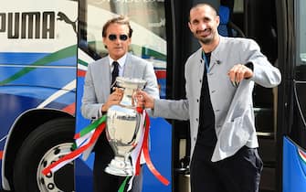 1233942218 Italy's coach Roberto Mancini (L) and Italy's defender Giorgio Chiellini carry the UEFA EURO 2020 trophy as players and staff of Italy's national football team arrive to attend a ceremony at the Quirinale presidential palace in Rome on July 12, 2021, a day after Italy won the UEFA EURO 2020 final football match between Italy and England. (Photo by Vincenzo PINTO / AFP) (Photo by VINCENZO PINTO/AFP via Getty Images)