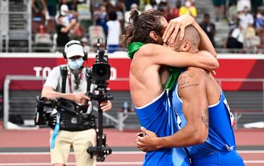 epa09385626 Gold Medalists in Men'sHigh Jump Gianmarco Tamberi of Italy (L) and gold medalist in Men's 100m Marcell Lamont Jacobs of Italy (R) celebrate during the Athletics events of the Tokyo 2020 Olympic Games at the Olympic Stadium in Tokyo, Japan, 01 August 2021.  EPA/CHRISTIAN BRUNA