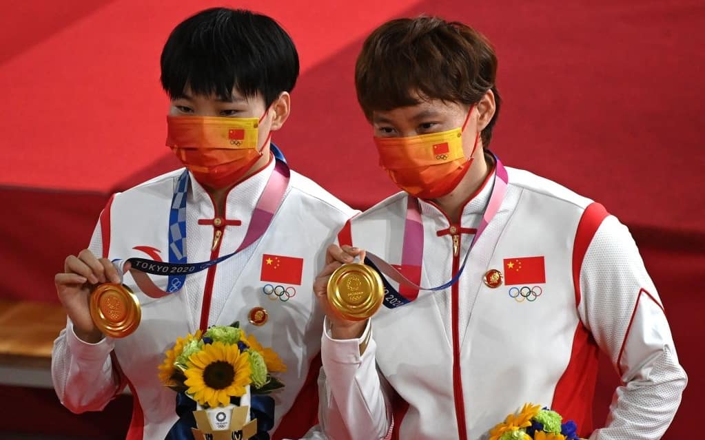 Gold medallists China's Bao Shanju (L) and China's Zhong Tianshi pose with their medals on the podium after the women's track cycling team sprint finals during the Tokyo 2020 Olympic Games at Izu Velodrome in Izu, Japan, on August 2, 2021. (Photo by Greg Baker / AFP) (Photo by GREG BAKER/AFP via Getty Images)