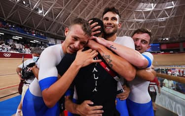 IZU, JAPAN - AUGUST 04: (L-R) Jonathan Milan, Filippo Ganna and Simone Consonni of Team Italy are congratulated from they team coach after winning the gold medal and to set a new World record during the Men's team pursuit finals, gold medal of the track cycling on day twelve of the Tokyo 2020 Olympic Games at Izu Velodrome on August 04, 2021 in Izu, Japan. (Photo by Justin Setterfield/Getty Images)