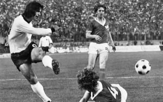 HAMBURG, GERMANY - JUNE 22:  West German forward Gerd Mnller kicks the ball past East German defender Konrad Weise (4) as forward Martin Hoffmann looks on during the  World Cup first round match between East Germany and West Germany 22 June 1974 in Hamburg. East Germany won 1-0 on a goal by forward Juergen Sparwasser. AFP PHOTO  (Photo credit should read STAFF/AFP via Getty Images)