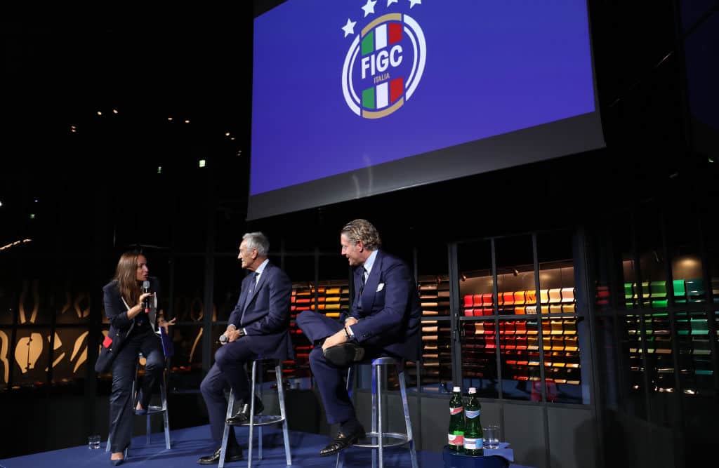 MILAN, ITALY - OCTOBER 04: Presenter Camila Raznovich talks with the President of FIGC Gabriele Gravina and Lapo Elkann at the unveiling of the FIGC new institutional logo at Garage Italia on October 04, 2021 in Milan, Italy. (Photo by Vincenzo Lombardo/Getty Images)