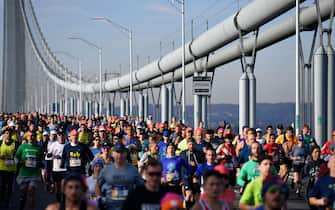 Runners cross the Verrazzano-Narrows Bridge during the 2021 TCS New York City Marathon in New York on November 7, 2021. - After a forced break in 2020, the New York City Marathon is back on for its 50th edition, and with it the countless opportunities to run it for charity, an industry that has become a staple, and hopes to take off again after the pandemic. (Photo by ANGELA  WEISS / AFP) (Photo by ANGELA  WEISS/AFP via Getty Images)