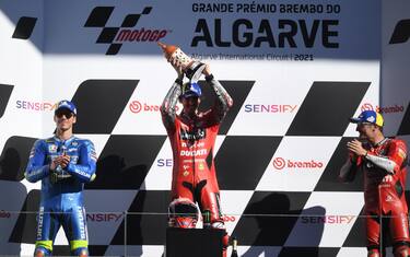 Winner Ducati Italian rider Francesco Bagnaia (C), second-placed Suzuki Spanish rider Joan Mir (L) and third-placed Ducati Australian rider Jack Miller celebrate on the podium after the MotoGP race of the Portuguese Grand Prix at the Algarve International Circuit in Portimao, on November 7, 2021. (Photo by PATRICIA DE MELO MOREIRA / AFP) (Photo by PATRICIA DE MELO MOREIRA/AFP via Getty Images)