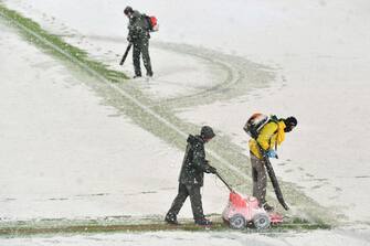 Stadium employees blow the snow covering the pitch ahead of the UEFA Champions League Group F football match between Atalanta and Villarreal on December 8, 2021 at the Atleti Azzurri d'Italia stadium in Bergamo. (Photo by Isabella BONOTTO / AFP) (Photo by ISABELLA BONOTTO/AFP via Getty Images)