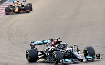 Mercedes' British driver Lewis Hamilton (R) drives ahead of Red Bull's Dutch driver Max Verstappen at the Yas Marina Circuit during the Abu Dhabi Formula One Grand Prix on December 12, 2021. (Photo by ANDREJ ISAKOVIC / AFP) (Photo by ANDREJ ISAKOVIC/AFP via Getty Images)