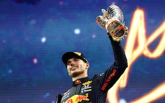 ABU DHABI, UNITED ARAB EMIRATES - DECEMBER 12: Race winner and 2021 F1 World Drivers Champion Max Verstappen of Netherlands and Red Bull Racing celebrates on the podium during the F1 Grand Prix of Abu Dhabi at Yas Marina Circuit on December 12, 2021 in Abu Dhabi, United Arab Emirates. (Photo by Mark Thompson/Getty Images)