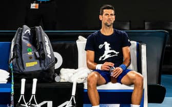 epaselect epa09684505 Novak Djokovic of Serbia rests during a practice session ahead of the Australian Open Grand Slam tennis tournament at Melbourne Park in Melbourne, Australia, 14 January 2022. The Australian federal government has re-cancelled Novak Djokovic's visa.  EPA/DIEGO FEDELE  AUSTRALIA AND NEW ZEALAND OUT