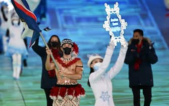American Samoa's flag bearer Nathan Crumpton (L) parades during the opening ceremony of the Beijing 2022 Winter Olympic Games, at the National Stadium, known as the Bird's Nest, in Beijing, on February 4, 2022. (Photo by Manan VATSYAYANA / AFP) (Photo by MANAN VATSYAYANA/AFP via Getty Images)
