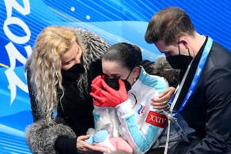 BEIJING, CHINA - FEBRUARY 17: Kamila Valieva of Team ROC reacts as they wait for their score with choreographer Daniil Gleikhengauz (R) and coach Eteri Tutberidze (L) after the Women Single Skating Free Skating on day thirteen of the Beijing 2022 Winter Olympic Games at Capital Indoor Stadium on February 17, 2022 in Beijing, China. (Photo by David Ramos/Getty Images)