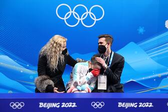 BEIJING, CHINA - FEBRUARY 17: Kamila Valieva of Team ROC reacts to their score with choreographer Daniil Gleikhengauz (R) and coach Eteri Tutberidze (L) after the Women Single Skating Free Skating on day thirteen of the Beijing 2022 Winter Olympic Games at Capital Indoor Stadium on February 17, 2022 in Beijing, China. (Photo by Matthew Stockman/Getty Images)