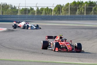Ferrari's Spanish driver Carlos Sainz Jr (foreground) leads Alfa Romeo's Finnish driver Kimi Raikkonen during the third day of the Formula One (F1) pre-season testing at the Bahrain International Circuit in the city of Sakhir on March 14, 2021. (Photo by Mazen MAHDI / AFP) (Photo by MAZEN MAHDI/AFP via Getty Images)