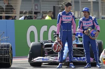 Alpine's French driver Esteban Ocon (L) and Alpine's Spanish driver Fernando Alonso pose in front of their car during the first day of Formula One (F1) pre-season testing at the Bahrain International Circuit in the city of Sakhir on March 12, 2021. (Photo by Mazen MAHDI / AFP) (Photo by MAZEN MAHDI/AFP via Getty Images)
