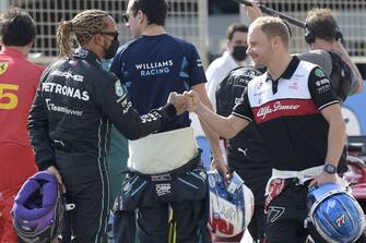 Mercedes' British driver Lewis Hamilton (L) greets former teammate Alfa Romeo's Finnish driver Valtteri Bottas during the first day of Formula One (F1) pre-season testing at the Bahrain International Circuit in the city of Sakhir on March 12, 2021. (Photo by Mazen MAHDI / AFP) (Photo by MAZEN MAHDI/AFP via Getty Images)