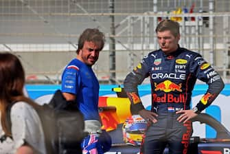 Alpine's Spanish driver Fernando Alonso (L) speaks with Red Bull's Dutch driver Max Verstappen during the first day of Formula One (F1) pre-season testing at the Bahrain International Circuit in the city of Sakhir on March 12, 2021. (Photo by Giuseppe CACACE / AFP) (Photo by GIUSEPPE CACACE/AFP via Getty Images)