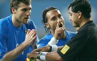 Italy's Angelo Di Livio (C) and Christian Vieri (L) protest as referee Byron Moreno (R) of Ecuador holds both yellow and red cards after he sent Italy's Francesco Totti off in extra time against South Korea during a second round World Cup Finals match in Taejon, June 18, 2002.
ANSA/DESMOND BOYLAN