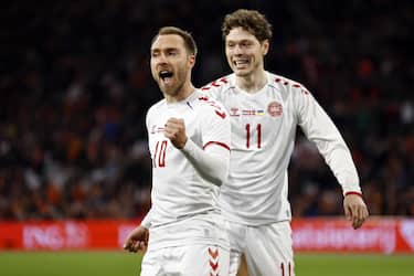 epa09852036 Christian Eriksen (L) of Denmark celebrates with teammate Andreas Skov Olsen after scoring his team's second goal during the International friendly soccer match between The Netherlands and Denmark at the Johan Cruijff ArenA in Amsterdam, Netherlands, 26 March 2022.  EPA/MAURICE VAN STEEN