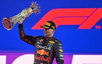 Red Bull's Dutch driver Max Verstappen raises his 1st-place trophy on the podium after the 2022 Saudi Arabia Formula One Grand Prix at the Jeddah Corniche Circuit on March 27, 2022. (Photo by ANDREJ ISAKOVIC / AFP) (Photo by ANDREJ ISAKOVIC/AFP via Getty Images)