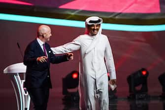 epa09864040 Emir of Qatar Sheikh Tamim bin Hamad al-Thani (R) reacts next to FIFA president Gianni Infantino (L) during the main draw of the FIFA World Cup 2022 at the Doha Exhibition & Convention Center (DECC) in Doha, Qatar, 01 April 2022.  EPA/LAURENT GILLIERON