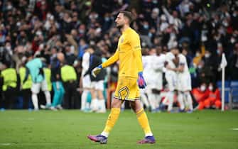 MADRID, SPAIN - MARCH 9: Goalkeeper of PSG Gianluigi Donnarumma looks on while Karim Benzema of Real Madrid celebrates his third goal with teammates during the UEFA Champions League Round Of Sixteen Leg Two match between Real Madrid and Paris Saint-Germain (PSG) at Estadio Santiago Bernabeu on March 9, 2022 in Madrid, Spain. (Photo by John Berry/Getty Images)