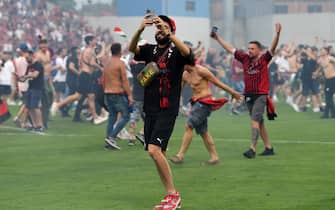 REGGIO NELL'EMILIA, ITALY - MAY 22: AC Milan fans celebrate on the pitch after their side finished the season as Serie A champions during the Serie A match between US Sassuolo and AC Milan at Mapei Stadium - Citta' del Tricolore on May 22, 2022 in Reggio nell'Emilia, Italy. (Photo by Chris Ricco/Getty Images)