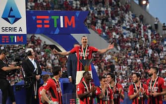 AC Milan's Swedish forward Zlatan Ibrahimovic (C), AC Milan's French forward Olivier Giroud (R) and teammates celebrate with the winner's trophy after AC Milan won the Italian Serie A football match between Sassuolo and AC Milan, securing the "Scudetto" championship on May 22, 2022 at the Mapei - Citta del Tricolore stadium in Sassuolo. (Photo by Tiziana FABI / AFP) (Photo by TIZIANA FABI/AFP via Getty Images)