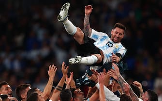Argentina's striker Lionel Messi is thrown into the air by his teammates as they celebrate their win on the pitch after the 'Finalissima' International friendly football match between Italy and Argentina at Wembley Stadium in London on June 1, 2022. - The Azzurri face the South American continental champions in the inaugural Finalissima at Wembley. (Photo by Adrian DENNIS / AFP) (Photo by ADRIAN DENNIS/AFP via Getty Images)