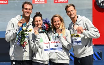 BUDAPEST, HUNGARY - JUNE 26: Bronze medalists Gregoria Paltrinieri, Giulia Gabbrielleschi, Ginevra Taddeucci and Domenico Acerenza of Team Italy hold up their medals on the podium following the Open Water Mixed 6km Relay on day one of the Budapest 2022 FINA World Championships at Lake Lupa on June 26, 2022 in Budapest, Hungary. (Photo by Quinn Rooney/Getty Images)