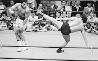 (Original Caption) 6/26/1976-Tokyo, Japan-: Muhammad Ali dances as Japanese wrestler Antonio Inoki tries a leg kick during the 4th round of their wrestling-boxing exhibition fight. Ali fought to a draw with Inoki.