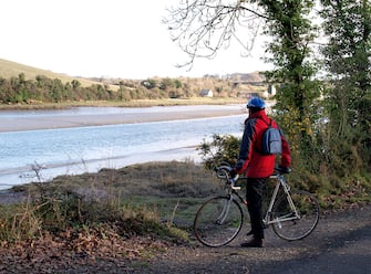 Cyclist on the Camel Trail, stopped to look at the view of the Camel Estuary near Wadebridge, Cornwall, UK. (Photo by: Education Images/Universal Images Group via Getty Images)