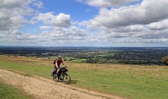 A man cycles along the South Downs Way near Brighton, East Sussex, as clouds gather ahead of predicted bad weather on Friday. (Photo by Gareth Fuller/PA Images via Getty Images)