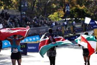 epa09570369 First place winner Albert Korir of Kenya (C) second place finisher Mohamed El Aaraby of Morocco (L) and Eyob Faniel of Italy, take a victory lap at the conclusion of the men's division at the 2021 TCS New York City Marathon in New York, New York, USA, 07 November 2021.  EPA/PETER FOLEY